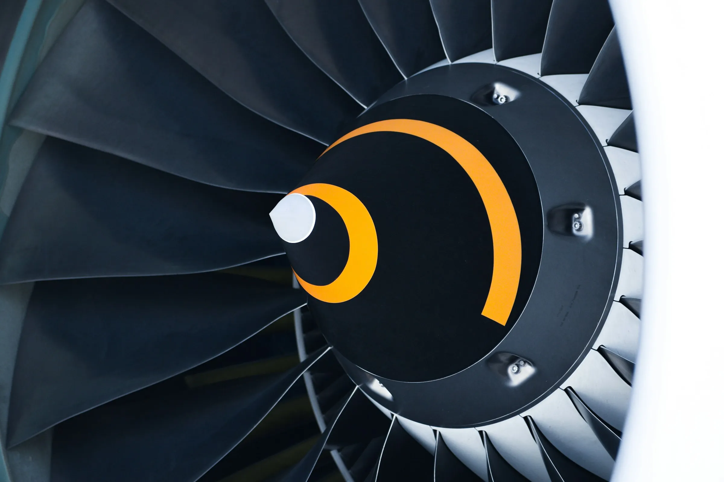 Close-up of a jet engine fan behind a white nacelle.